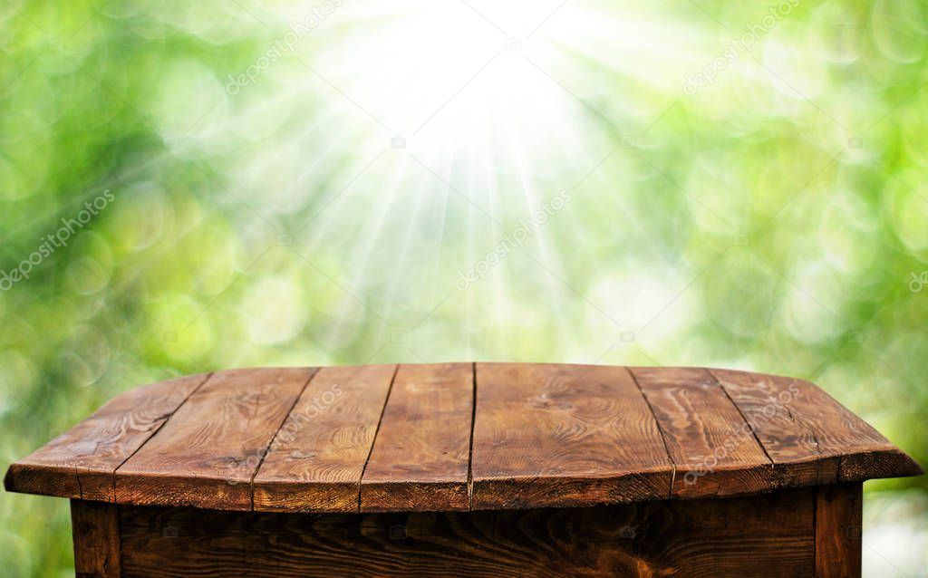 Empty wooden table with blurred natural background