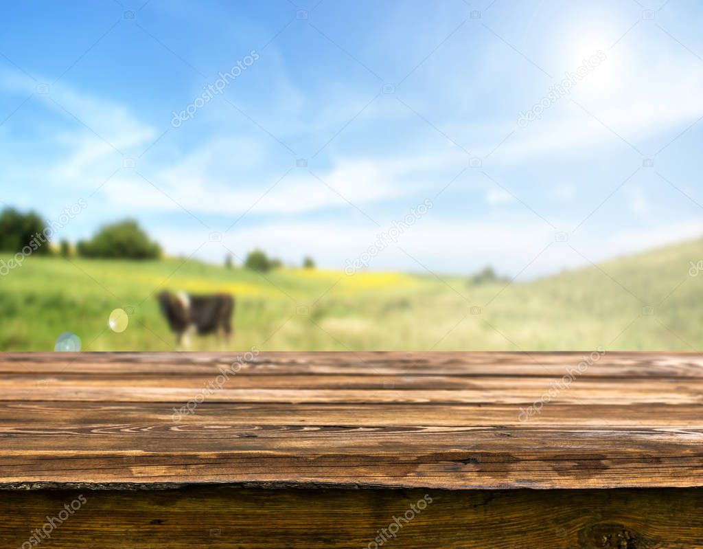 Empty wooden table with blurred natural background