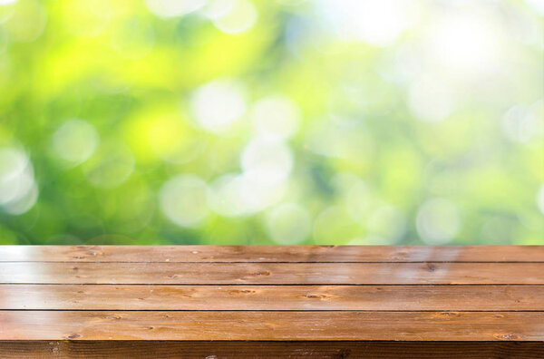 Empty wooden table with blurred spring background 