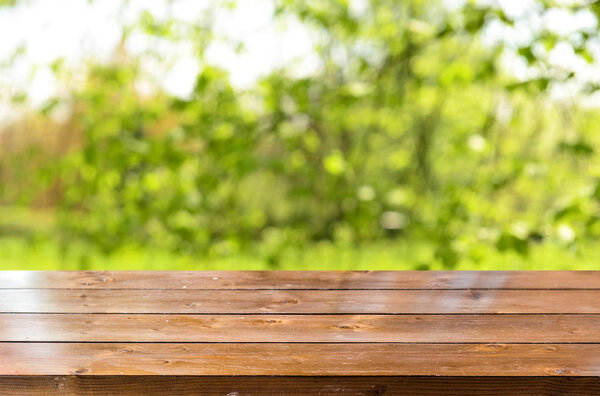 Empty wooden table with blurred spring background 