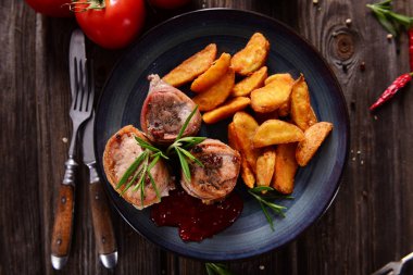 Pastırma patates dilimleri ile servis ile sarılmış et parçaları