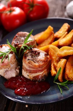 Pastırma patates dilimleri ile servis ile sarılmış et parçaları
