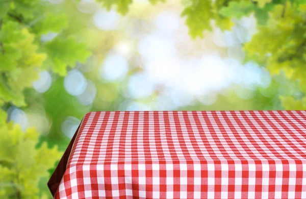 市松模様のテーブル クロスと自然な背景をぼかした写真空のテーブル — ストック写真