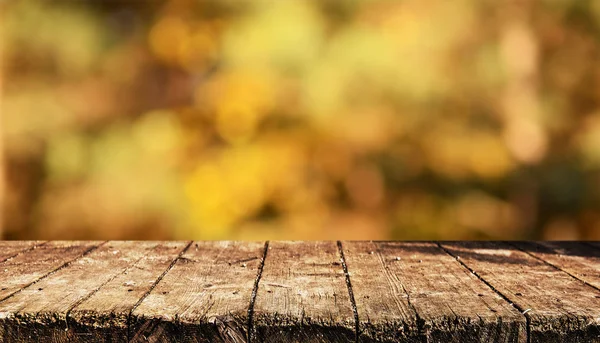 Empty wooden table with blurred natural background
