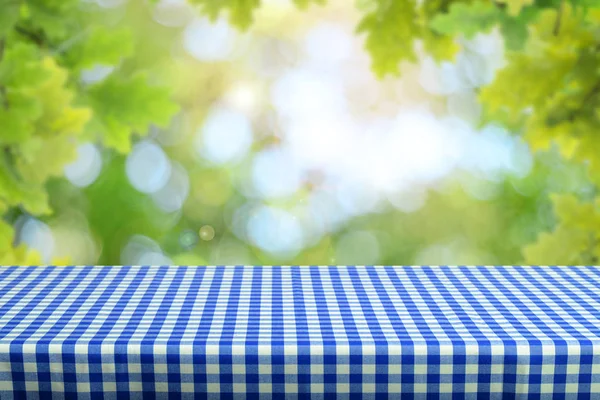 Lege Tabel Met Geruit Tafelkleed Onscherpe Natuurlijke Achtergrond — Stockfoto