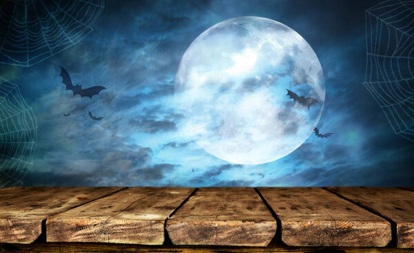 Empty wooden table with Halloween background