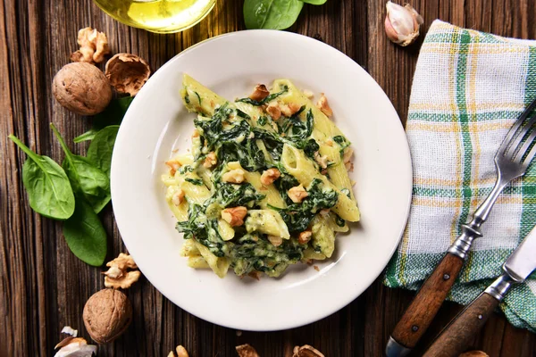 Penne pasta with spinach, gorgonzola cheese and walnuts