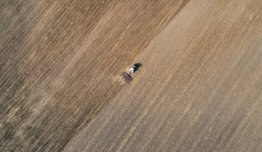 Sahada çalışan traktörün hava görüntüsü.