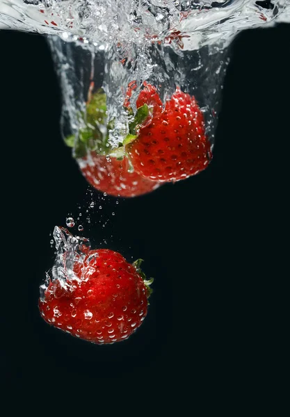 Fragole in acqua su fondo nero — Foto Stock