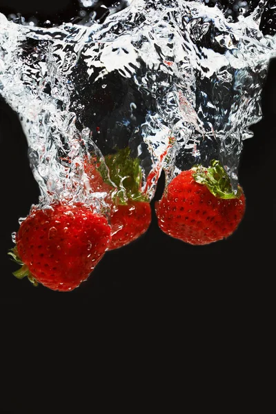 Fragole in acqua su fondo nero — Foto Stock