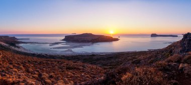 Berrak mavi gökyüzü ve deniz koyunda yarışan muhteşem dağ manzarası.