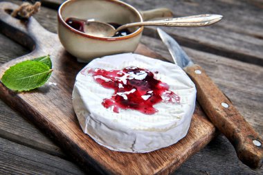 Fırından çıkan lezzetli peynirli camembert peyniri kızılcık sosuyla servis ediliyor.