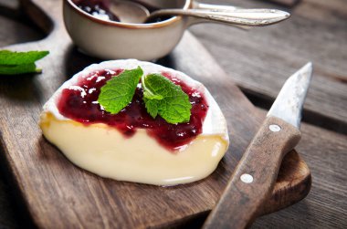 Fırından çıkan lezzetli peynirli camembert peyniri kızılcık sosuyla servis ediliyor.