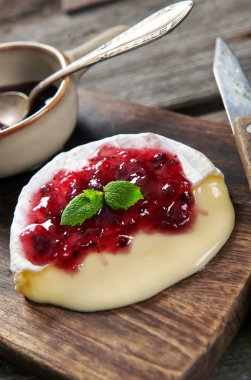 Fırından çıkan lezzetli peynirli camembert peyniri kızılcık sosuyla servis ediliyor.