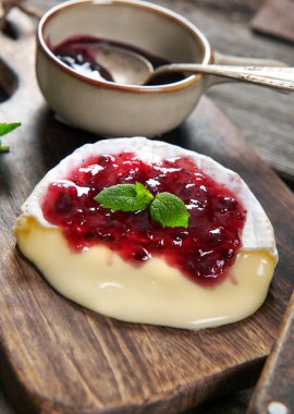 Fırından çıkan lezzetli peynirli camembert peyniri kızılcık sosuyla servis ediliyor.