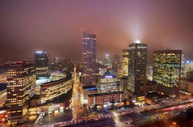 Geceleri sisli havada modern binaların olduğu şehir manzarası 