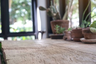 Arka planda saksıları olan tahta bir masanın yakın plan bulanık görüntüsü