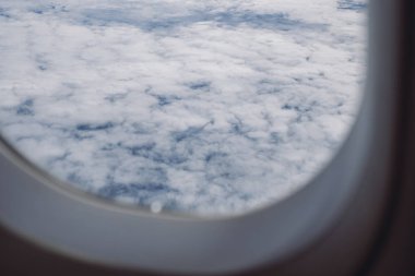 Mavi gökyüzü bulutlu günde bir uçak penceresinden