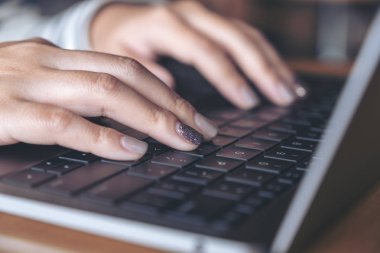 Portre resim kullanarak ve dizüstü klavye masada yazarak bir kadının elleri