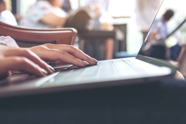 Dizüstü bilgisayar klavyesinde yazı yazan bir kadının ellerinin yakın plan görüntüsü 