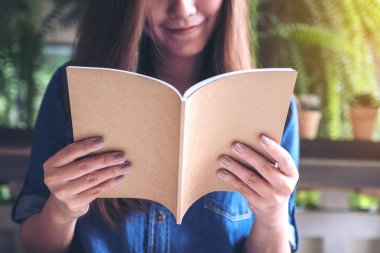 Portre resim güzel bir Asya kadının modern kafede bir kitap okuma 