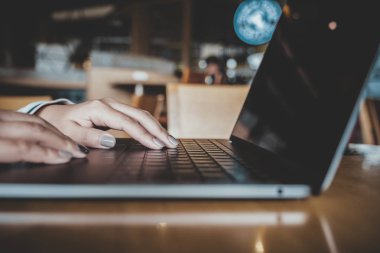 Portre resim kullanarak ve dizüstü klavye masada yazarak bir kadının elleri