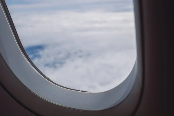 The blue sky on cloudy day through an airplane window