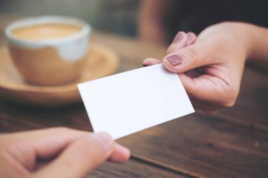 İş kadını ile kahve fincanı ahşap masa arka plan üzerinde kartvizit vererek iş adamı