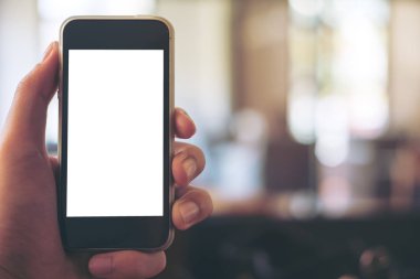 Boş beyaz siyah cep telefonu tutan el mockup görüntü vintage ahşap kafede ekran ve bokeh arka plan bulanıklık