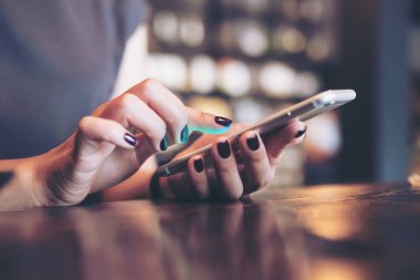 Bir iş kadının modern Café tutan ve dokunaklı akıllı telefon eller