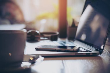 Dizüstü bilgisayar, akıllı telefon, kahve ve kulaklık ofiste ahşap tabloda portre resim