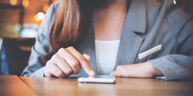 Kullanarak ve modern café'akıllı telefon dokunmadan bir Asya iş kadını