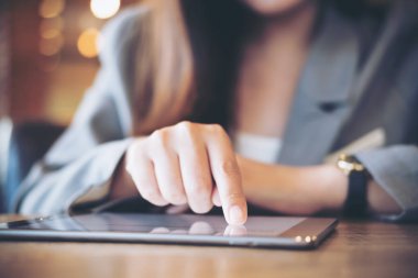 Bir iş kadının el ile işaretleme, dokunmaktan ve kullanarak tablet kafede arka plan bulanıklık