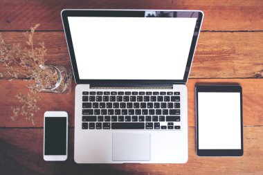 Cep telefonu, dizüstü ve tablet vintage ahşap masa arka plan üzerinde siyah ve beyaz mockup görüntü