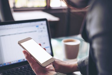 Hareket eden telefon ile latop boş beyaz ekran ile Cafe ahşap masa üzerinde tutan iş kadın görüntüsünü mockup