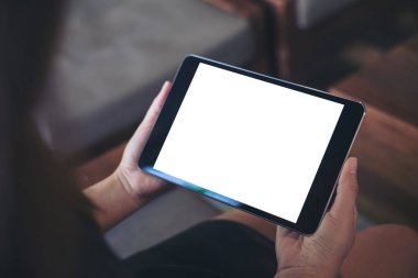 Kadının el ahşap kafede siyah tablet pc boş beyaz ekran ile tutarak mockup görüntü