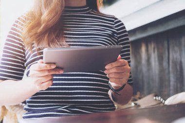 Bir kadın tutarak ve bir odada tablet PC'yi kullanma