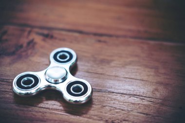 Ahşap masa üzerinde bir metal gümüş renk topluca spinner görüntüsünü üstten görünüm
