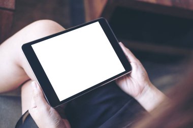 Siyah tablet pc boş beyaz ekran ile uyluk modern kafede tutan kadının el mockup görüntü