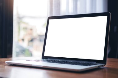Laptop ile pencere modern Cafe ahşap masa boş beyaz ekran görüntüsünü mockup