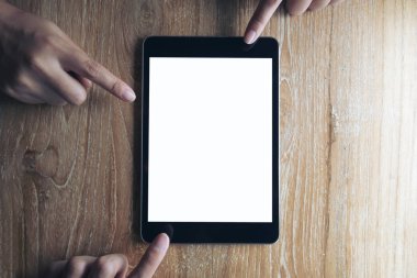 İş adamı mockup vintage ahşap masa arka plan boş beyaz ekran ile siyah tablet PC işaret üç parmak