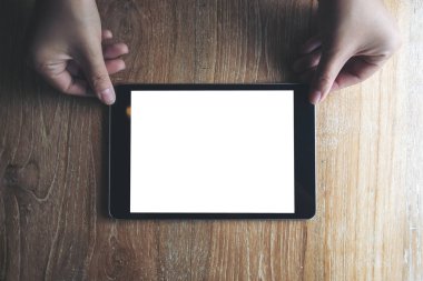 Holding, gösterilen ve somwone kahve fincanı vintage tahta masada boş beyaz ekran ile siyah tablet pc veren eller mockup görüntü