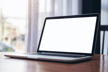 Laptop ile pencere modern Cafe ahşap masa boş beyaz ekran görüntüsünü mockup