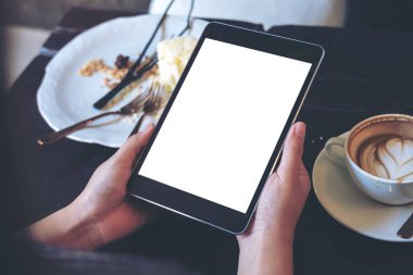 Görüntü kafede siyah tablet pc ile beyaz boş ekran, gıda, kek ve kahve kupaları ahşap masa üzerinde tutan kadının el kadar alay 