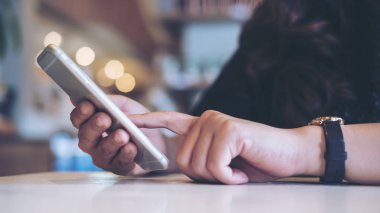 Tutan bir kadın, akıllı kullanarak ve işaret telefon modern Cafe