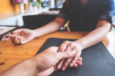 Bir erkek ve bir kadın birbirlerini duygu sevgi ile Restoran ahşap tablo elele