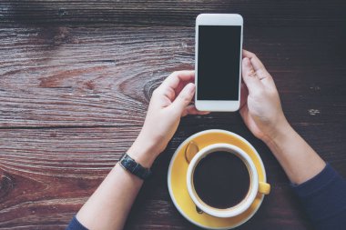 Beyaz cep telefonu ile boş siyah perde ile sarı holding eller mockup görüntü