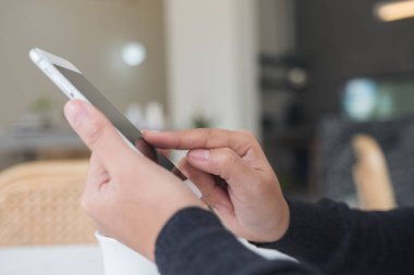 El ele tutuşmanın, kafedeki akıllı telefonu kullanmanın ve işaret etmenin yakın plan görüntüsü