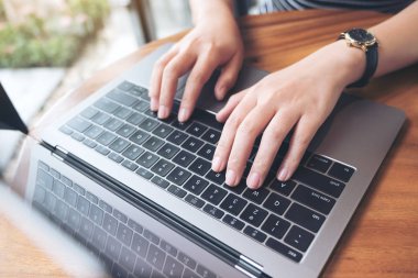 Bir iş kadınının ellerinin laptop klavyesinde çalışıp daktilo yazışının en üst görünümü 
