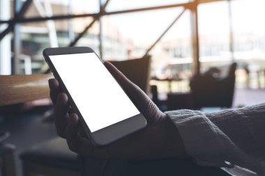Boş masaüstü ekranı olan beyaz cep telefonunu tutan el resmi 